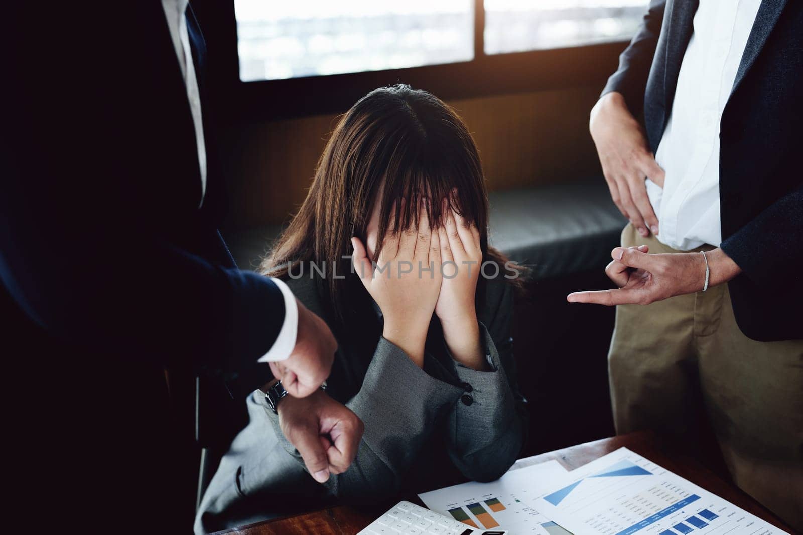 Portrait of a female worker showing failure at work and being reprimanded by a colleague by Manastrong