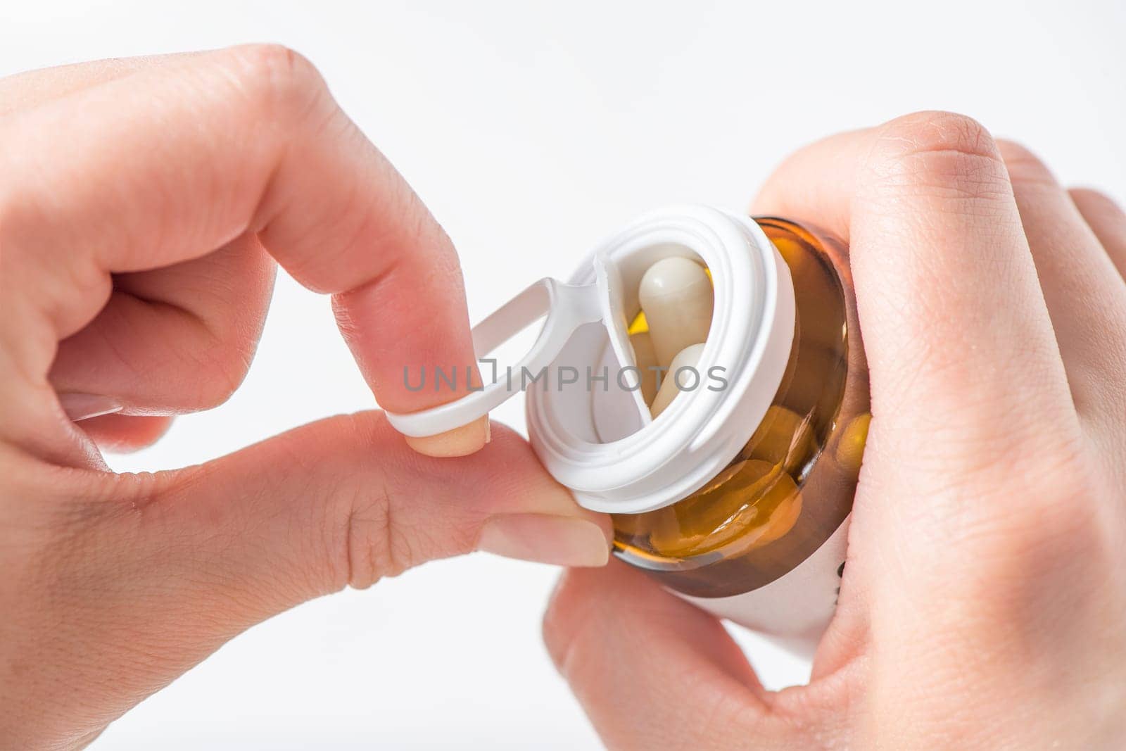 Antidepressants, taking pills for depression and disorders of the central nervous system. A woman's hand opens a bottle of antidepressants close-up on a white background