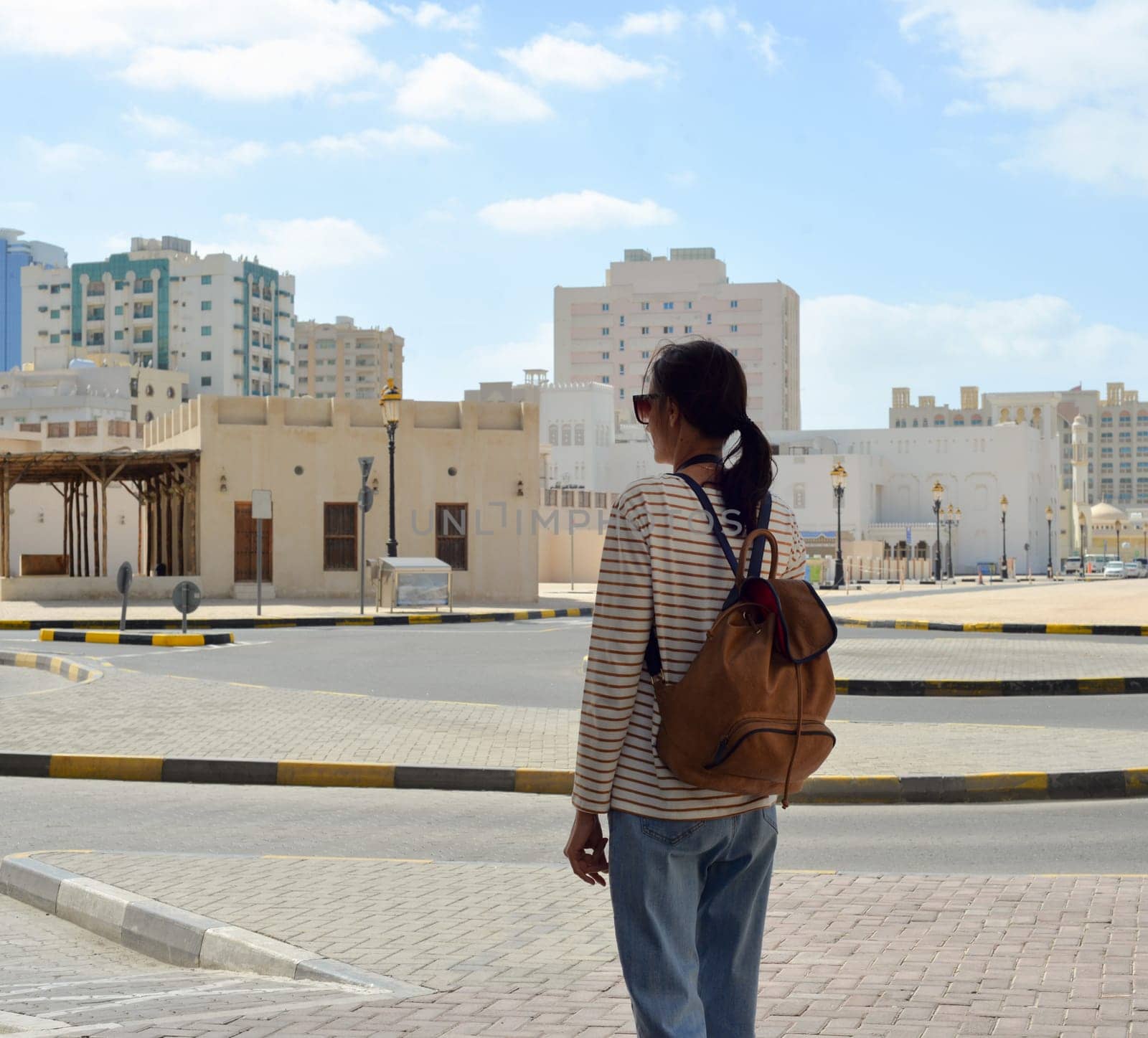 Woman tourist with a backpack on the Arab streets in the old part of Sharjah, UAE. by Ekaterina34