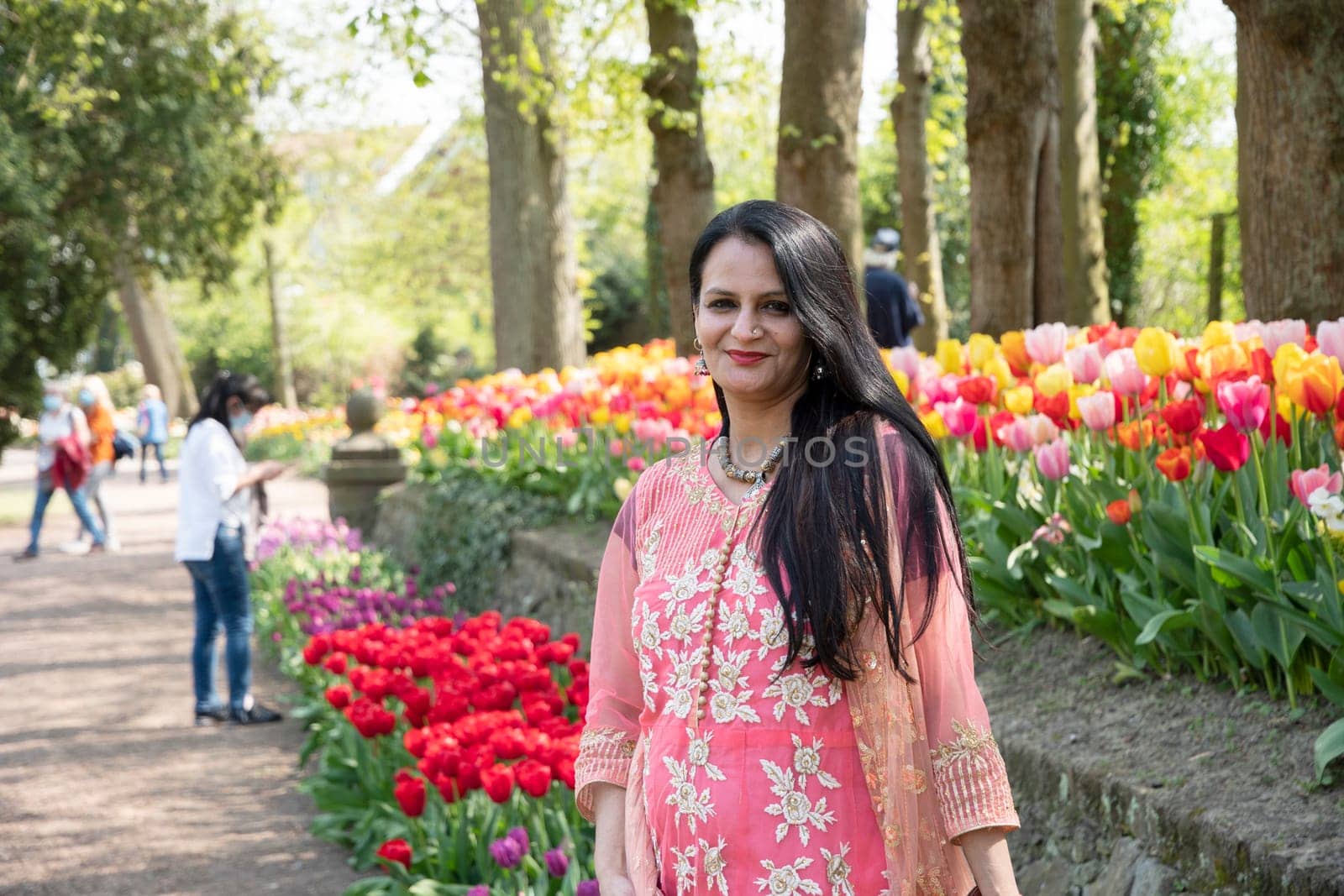 A beautiful Indian woman with black hair in a national Indian pink sari dress against the background. High quality photo