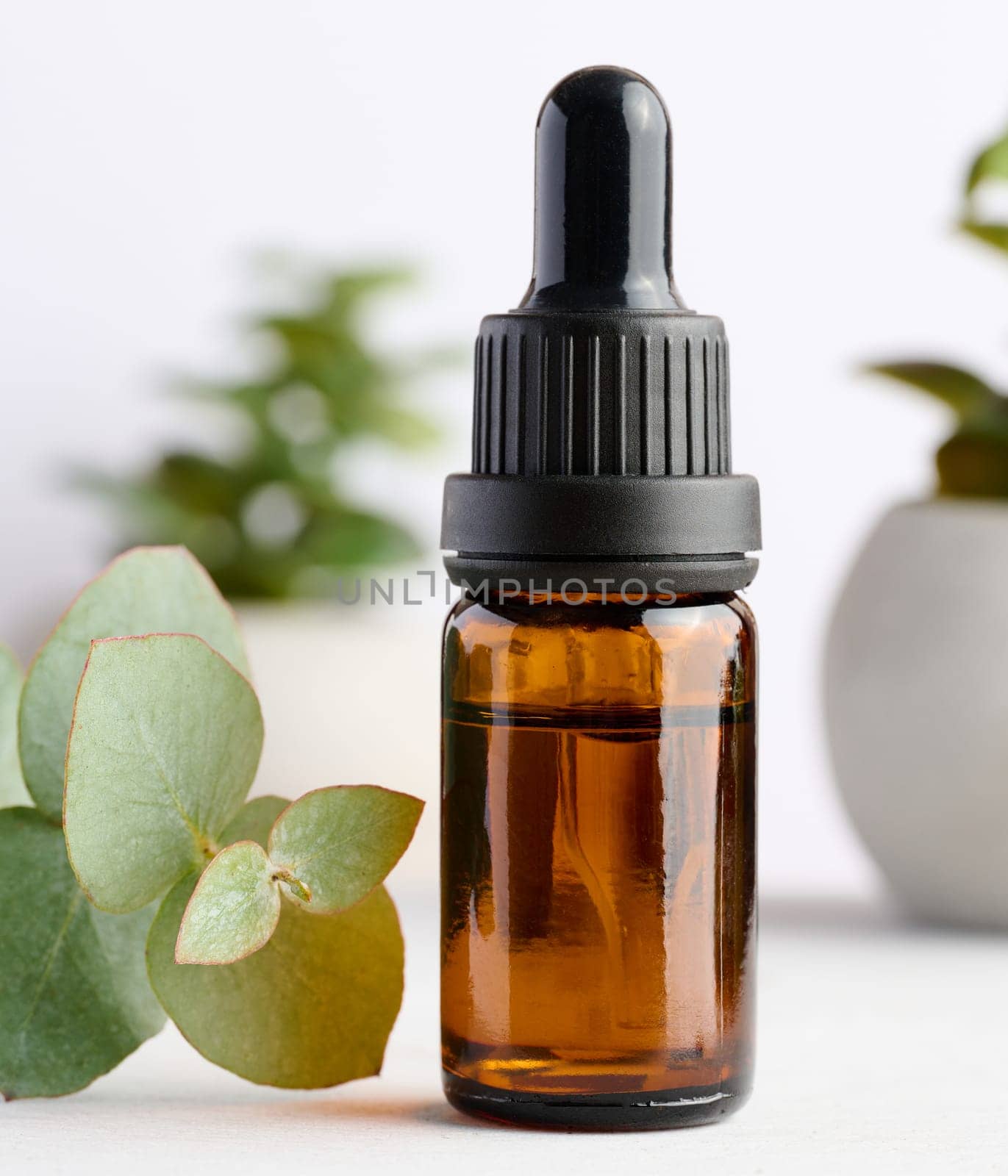 Brown glass bottle with pipette for cosmetic procedures on a wooden background by ndanko