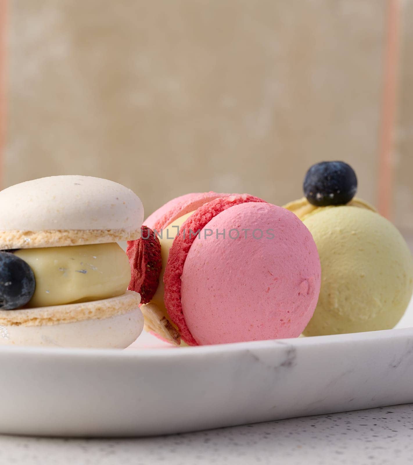 Baked macarons with different flavors on the table, dessert by ndanko