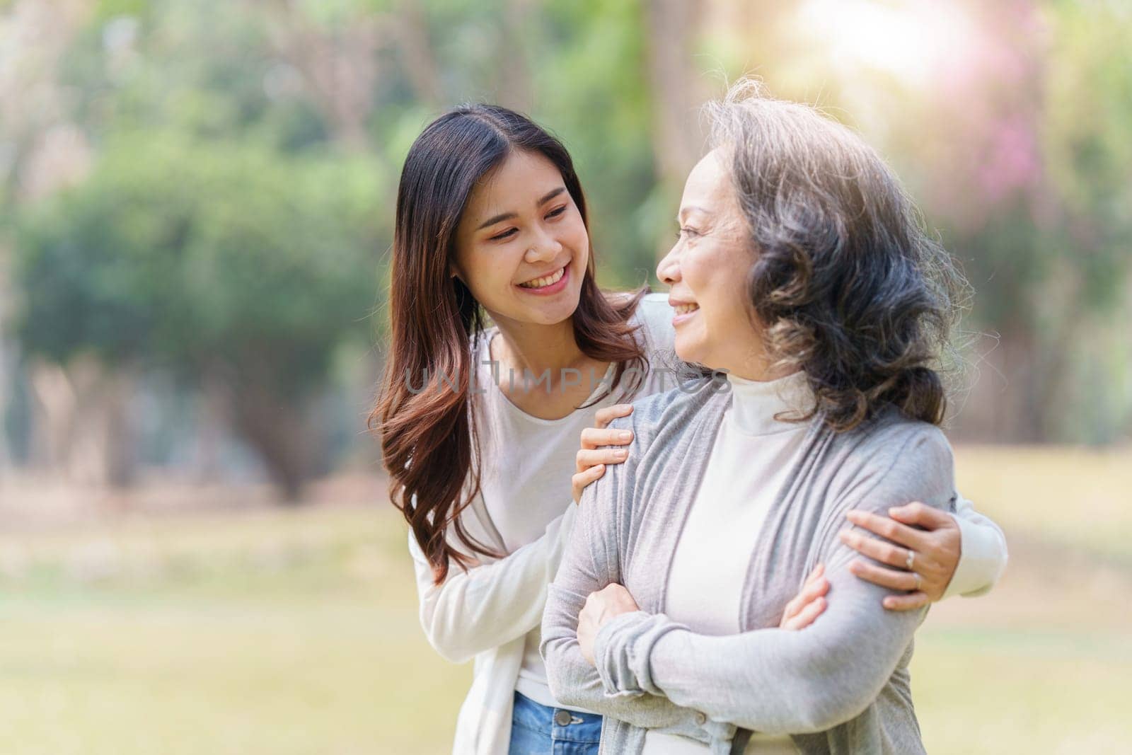 Portrait of an adult daughter with her elderly mother with hug and happy moment.