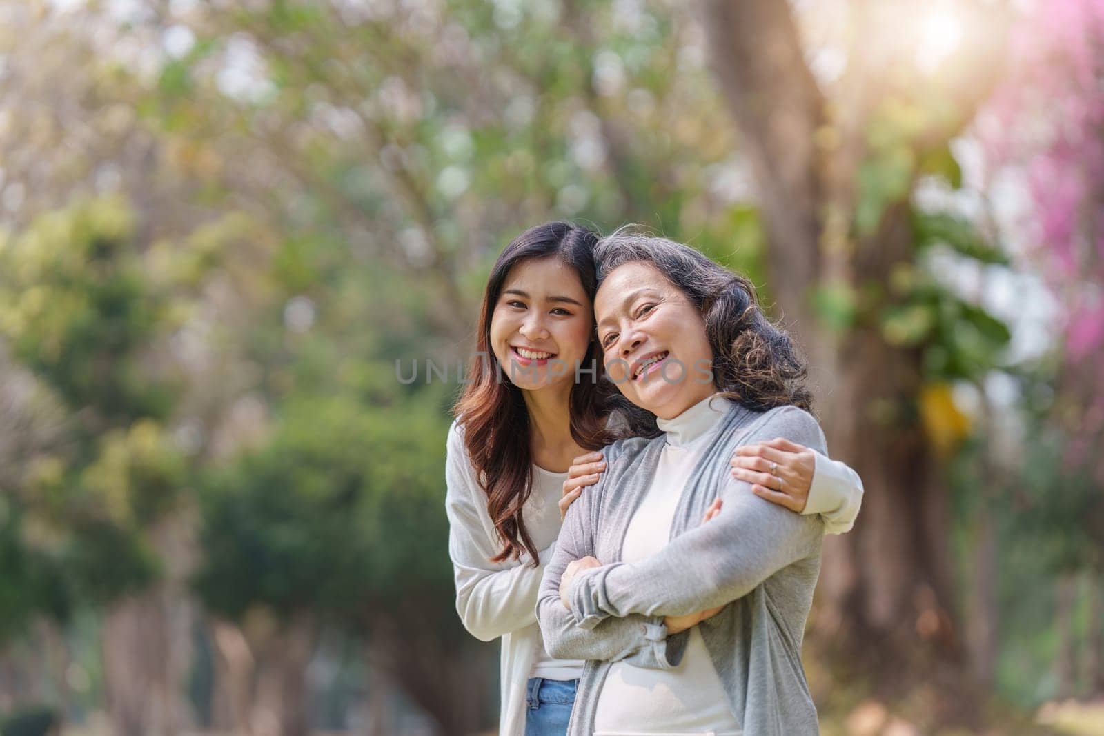 Portrait of an adult daughter with her elderly mother with hug and happy moment.
