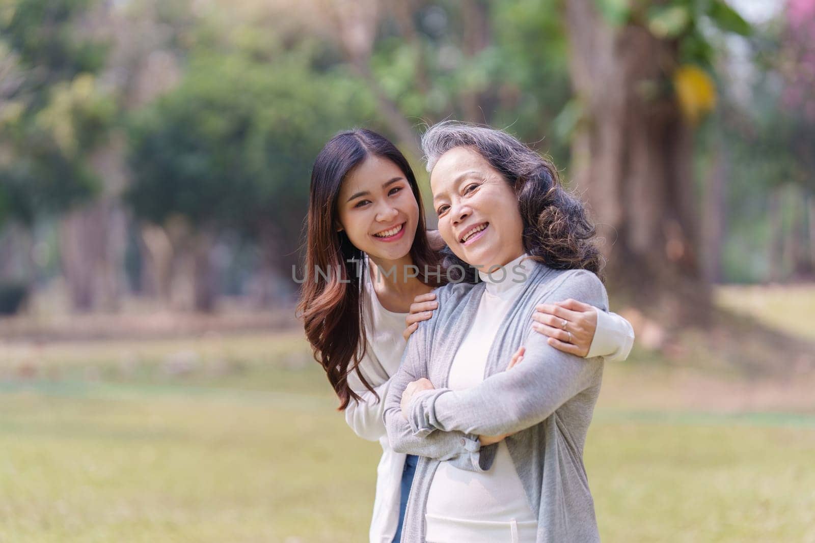 Portrait of an adult daughter with her elderly mother with hug and happy moment.