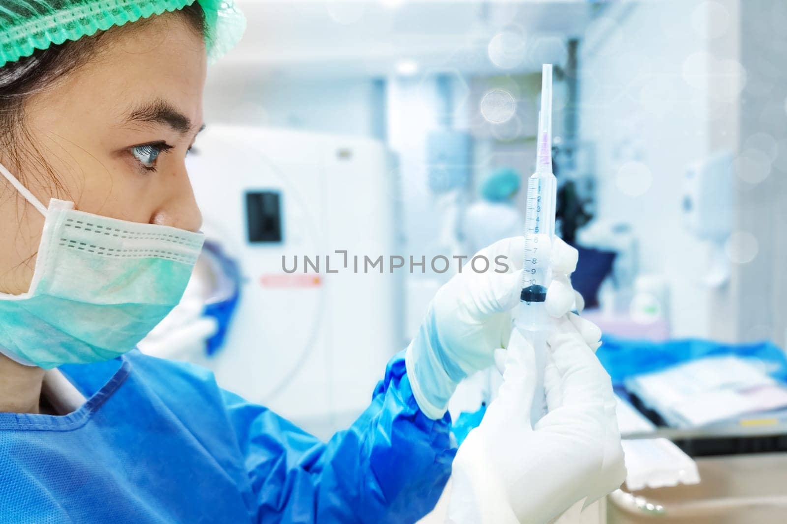 Woman Doctor with protective workwear holding Vaccine and syringe on CT Scan room background. Female doctor with face mask gloves in Hospital, preparing vaccine. by samunella