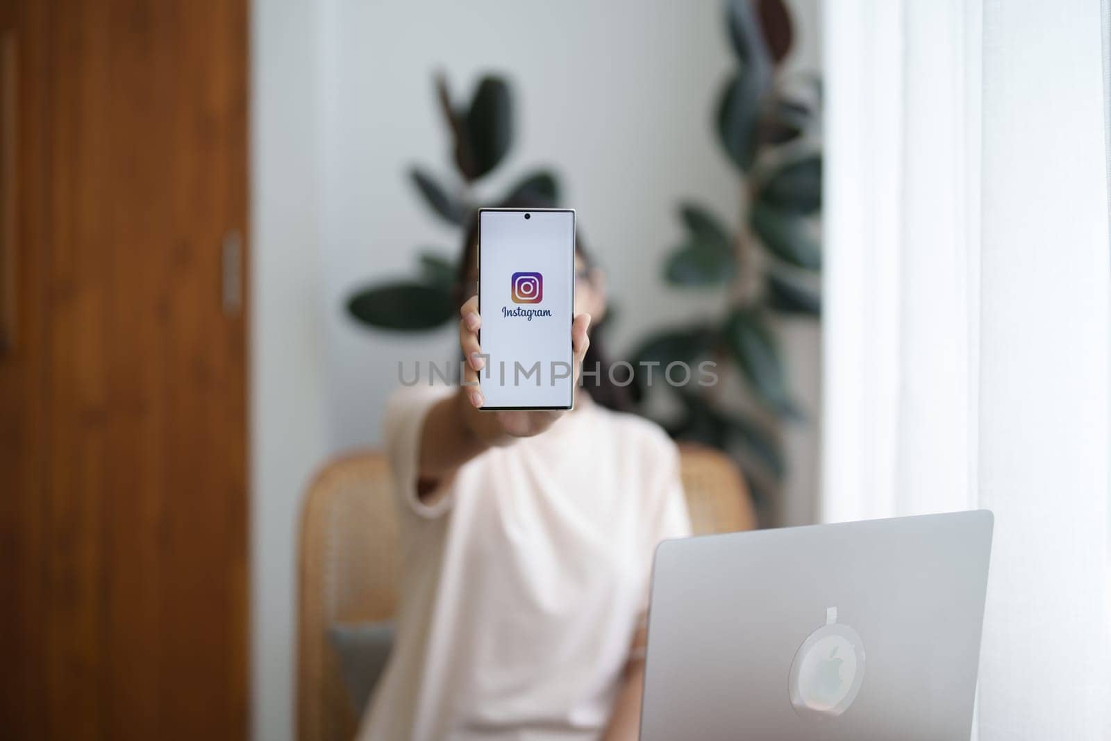 CHIANG MAI, THAILAND - Jul 09, 2022: A woman holds Smart android phone with Instagram application on the screen at cafe. by Manastrong