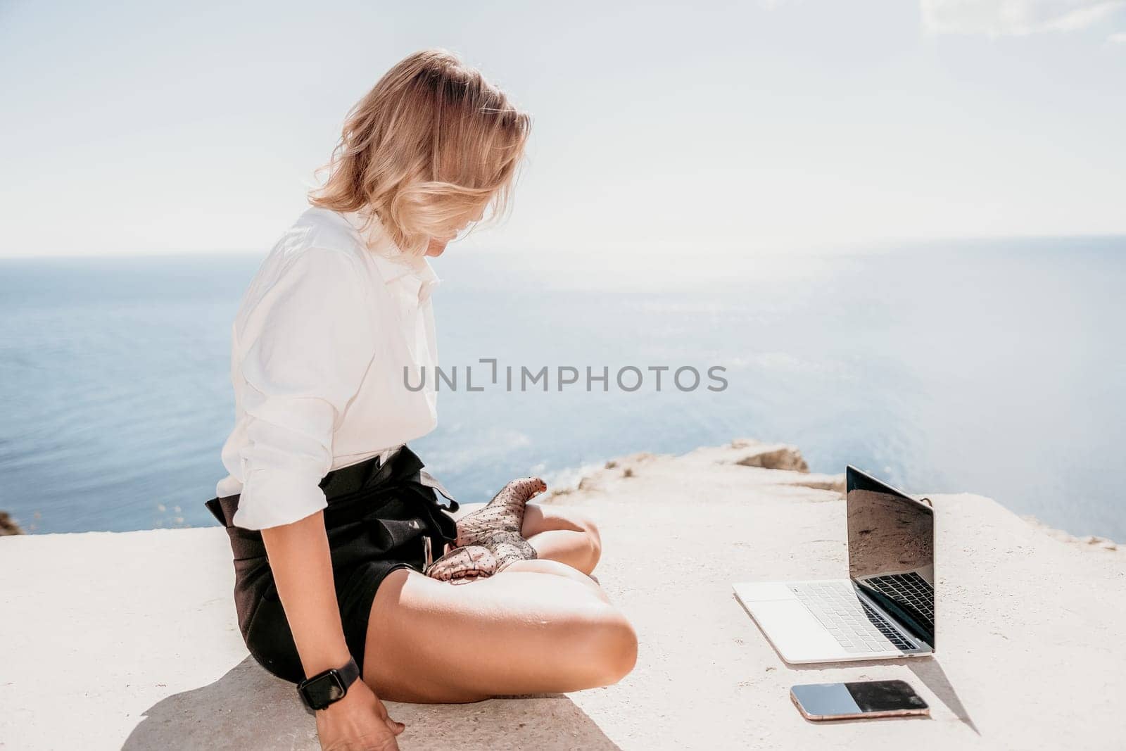 Woman sea laptop yoga. Business woman freelancer in yoga pose working over blue sea beach at laptop and meditates. Girl relieves stress from work. Freelance, digital nomad, travel and holidays concept by panophotograph