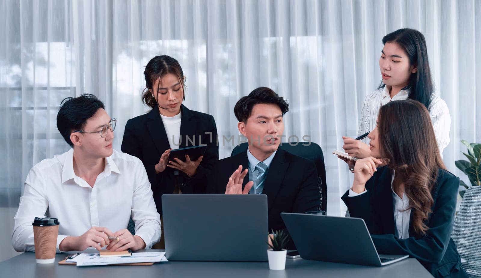 Harmony in office concept as business people analyzing dashboard paper together in workplace. Young colleagues give ideas at manager desk for discussion or strategy planning about project.