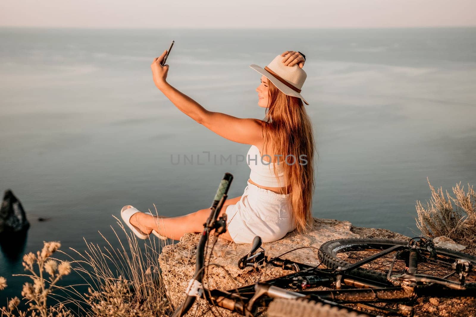 Woman travel sea. Young Happy woman in a long red dress posing on a beach near the sea on background of volcanic rocks, like in Iceland, sharing travel adventure journey