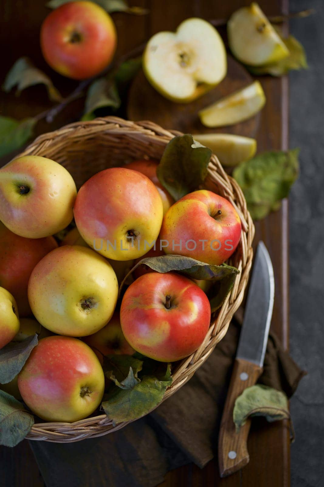 Ripe apples in a basket, with leaves around it by aprilphoto