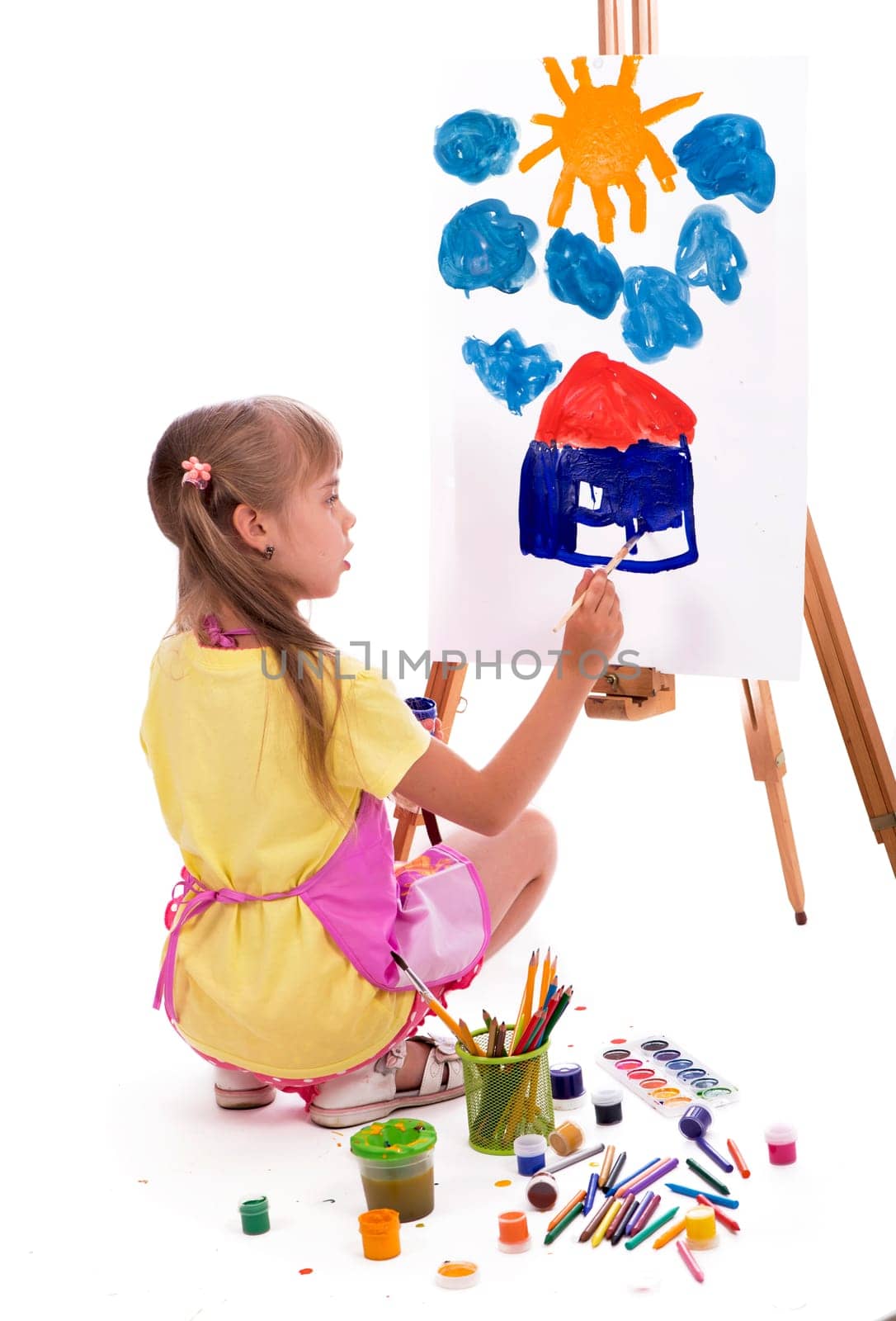 girl draws a house and the sun. artist kid girl painting over white background by aprilphoto