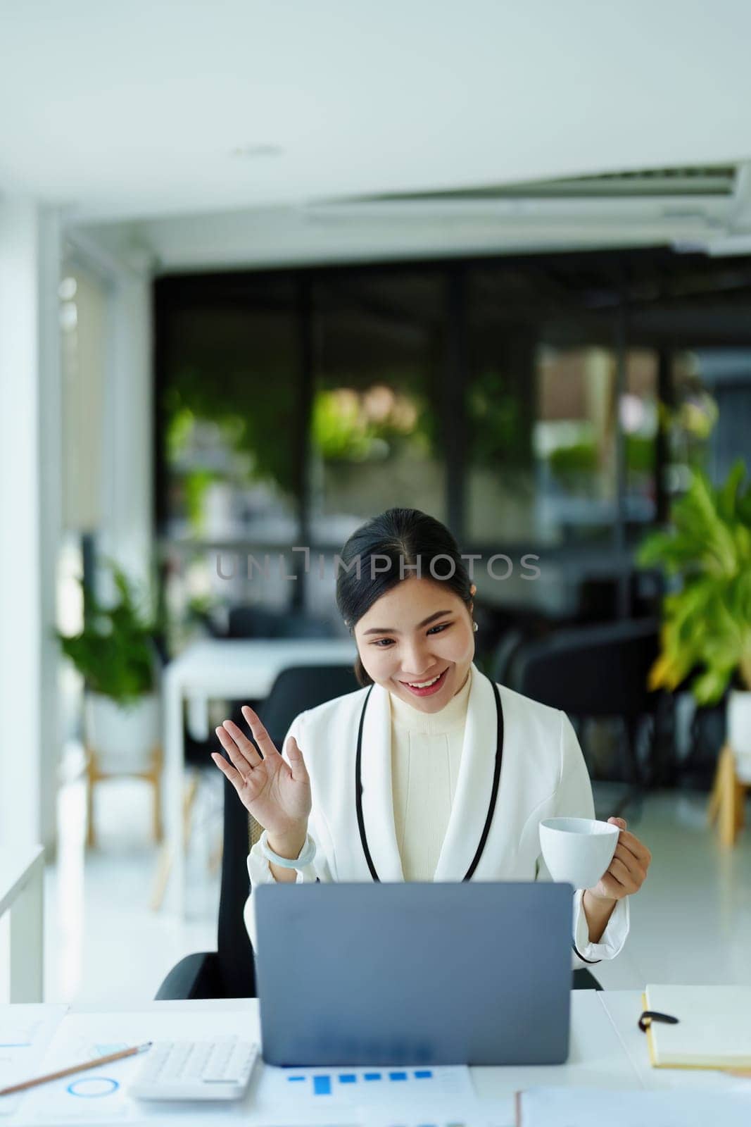 A portrait of a female employee using a computer video conferencing to discuss work through the Internet network.