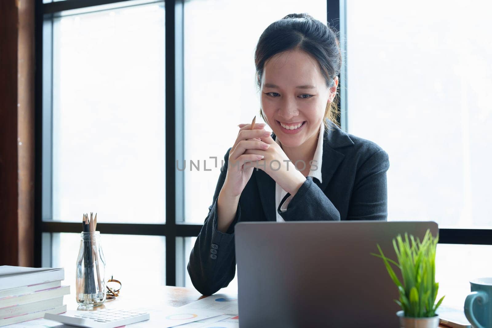 Portrait of a young woman drinking coffee while using a computer.