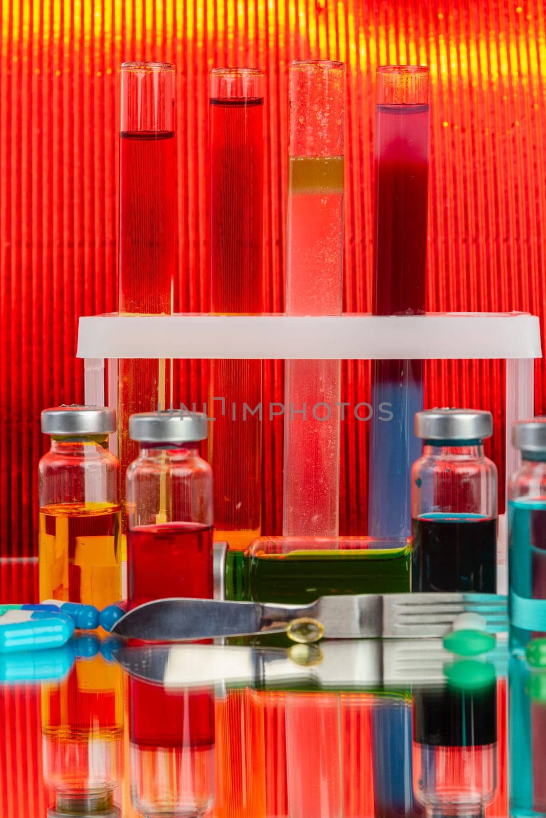 Collection of drug vials on red background. Scientific lab medicine reserarch.