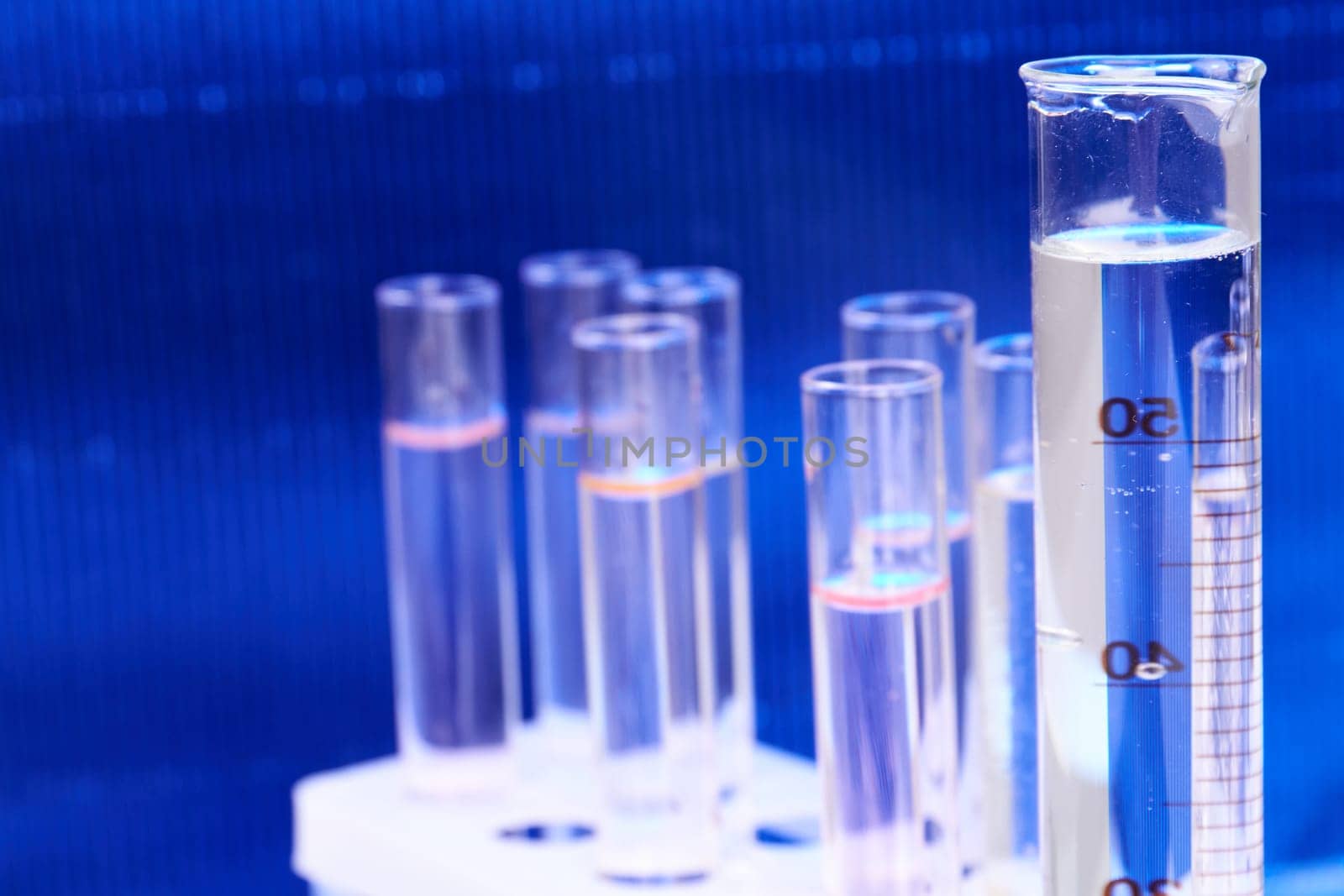 Set of glass test tubes on blue background. lab medical equipment concept.