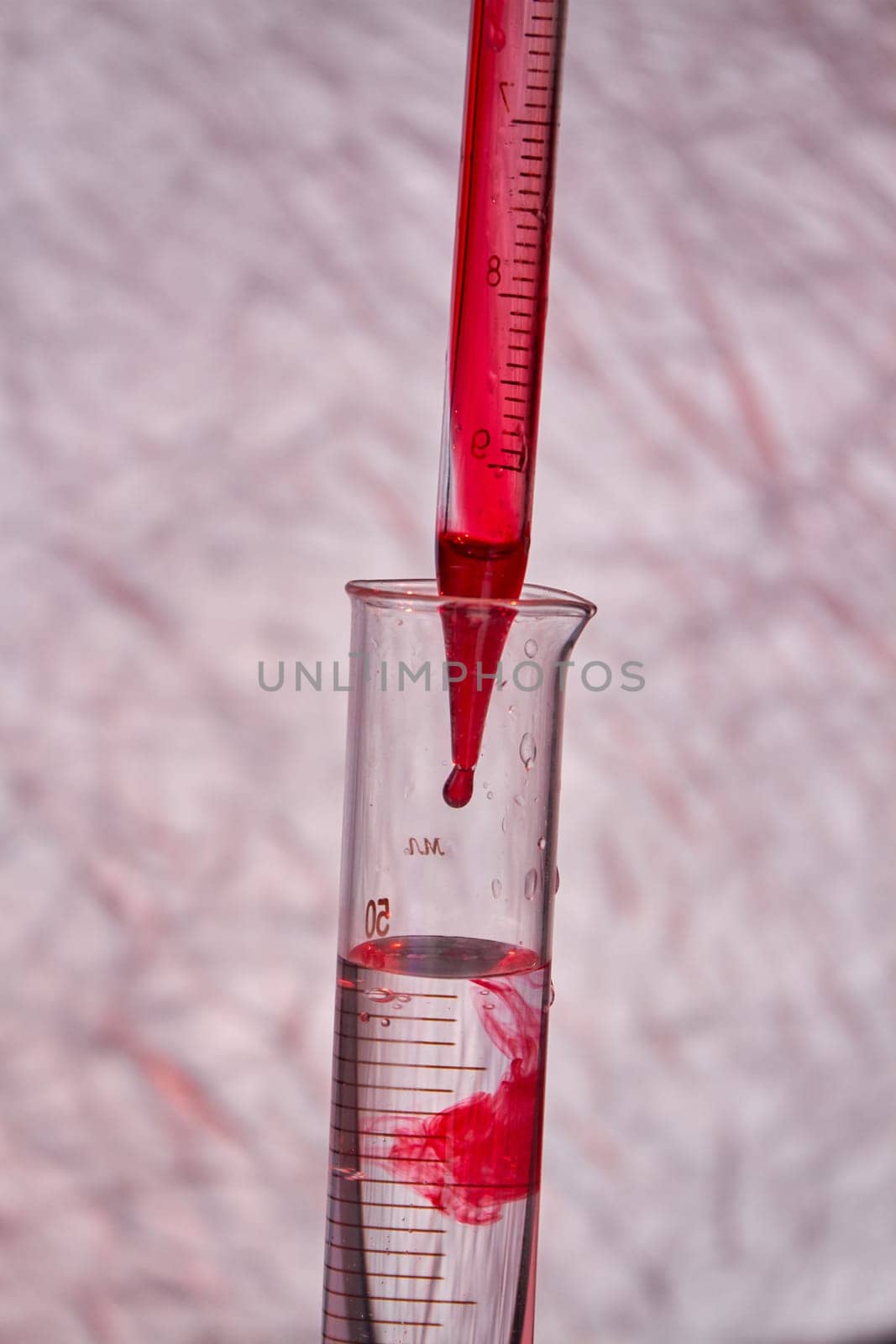 Close up pipette dropping blood into test tube. Blood test and analysis in medical research laboratory.