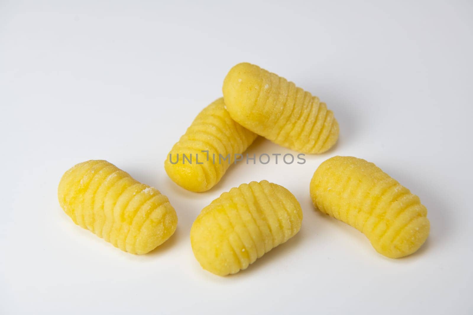 Pile of yellow eggs gnocchi dough dumplings isolated over the white background, High quality photo