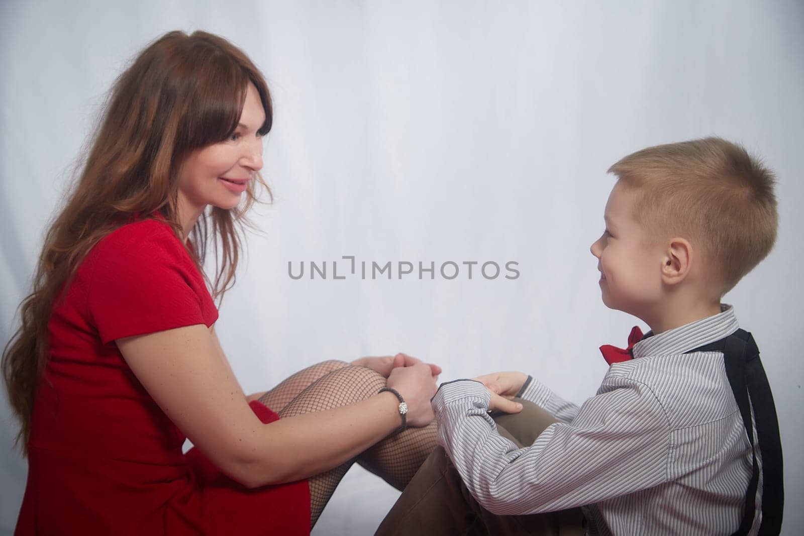 Woman with boy. Mom with son on a white background. Family portrait with mother and boy having fun together