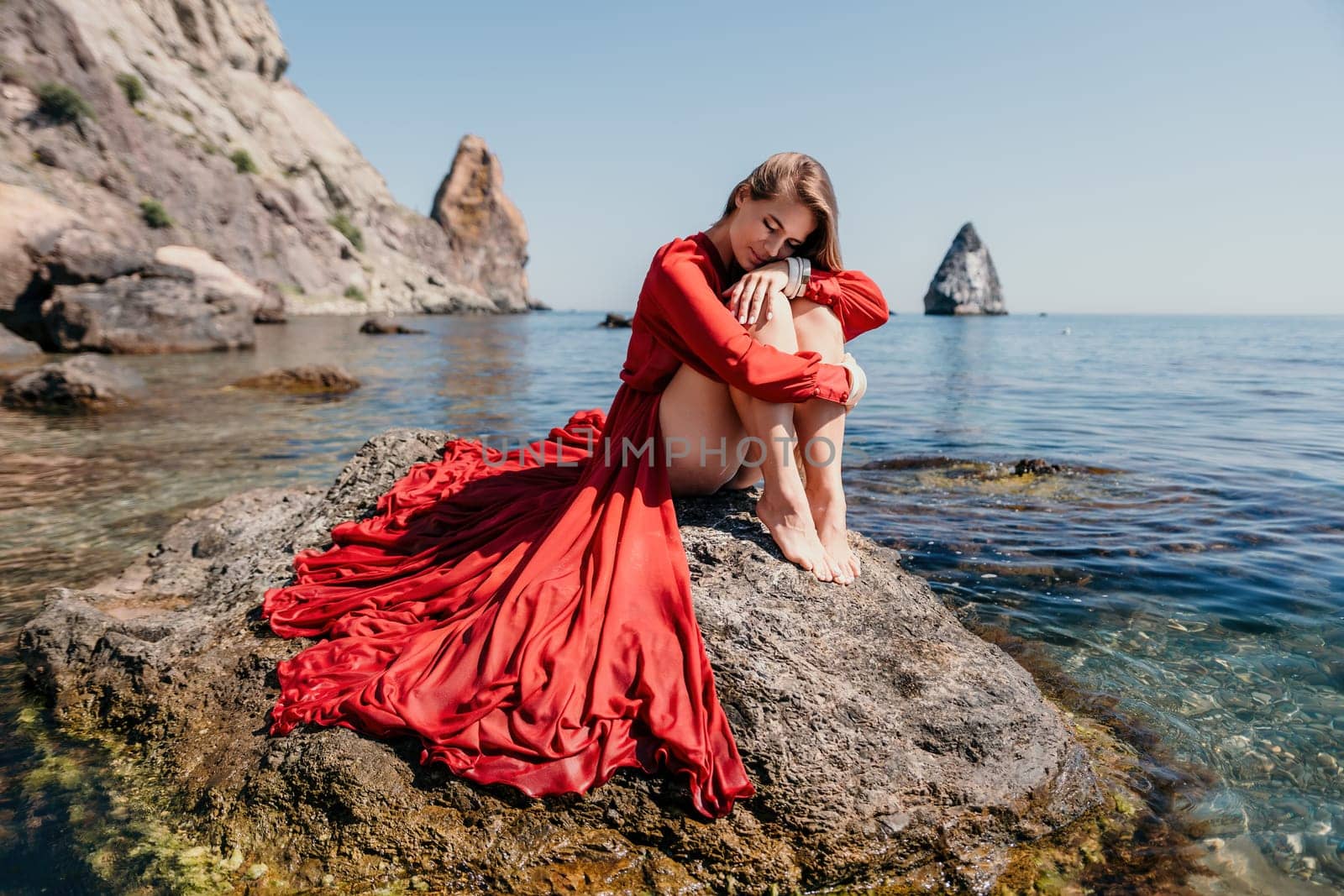 Woman travel sea. Happy tourist taking picture outdoors for memories. Woman traveler looks at the edge of the cliff on the sea bay of mountains, sharing travel adventure journey.