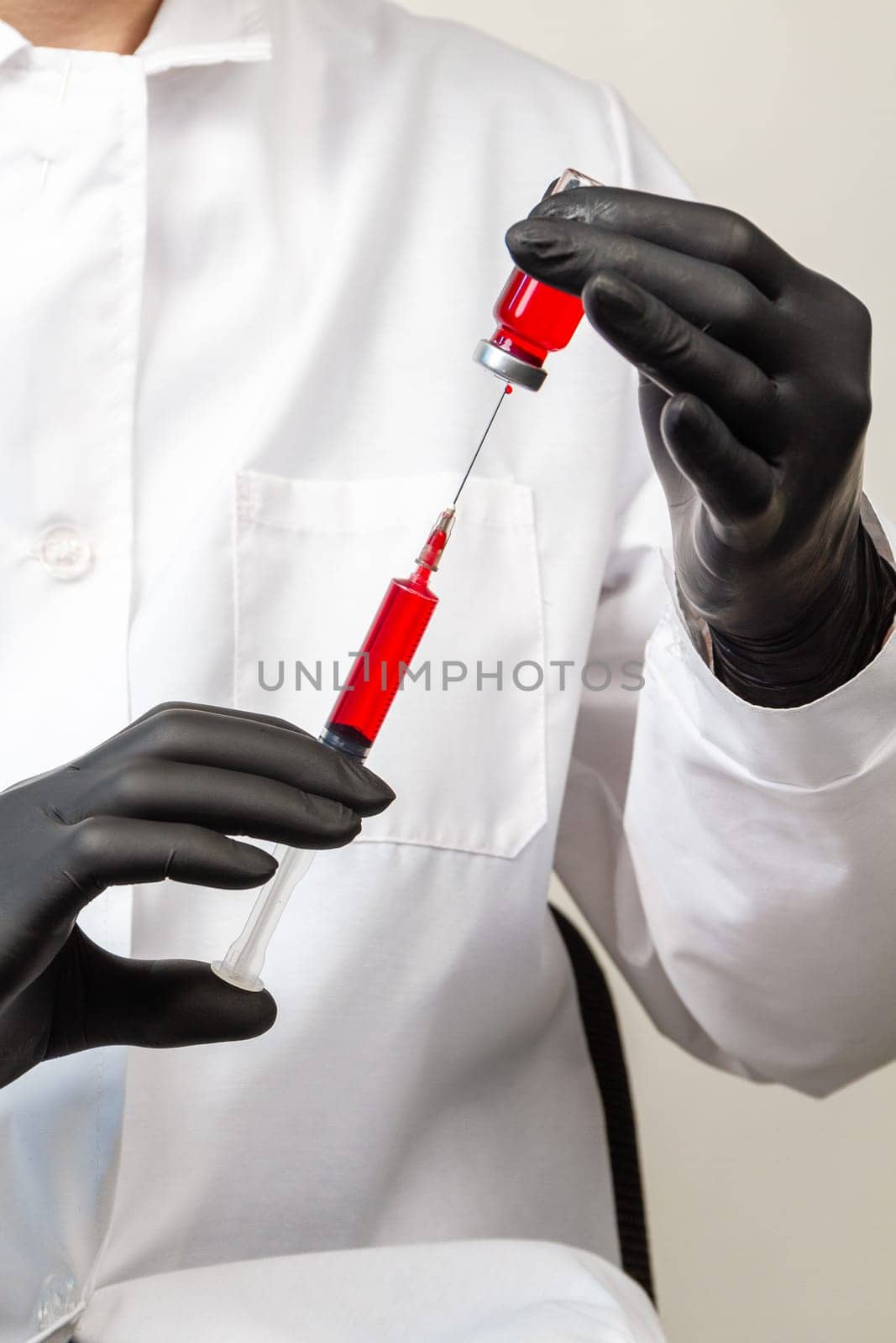 Doctors hands in black gloves filling syringe with medication. by super_picture