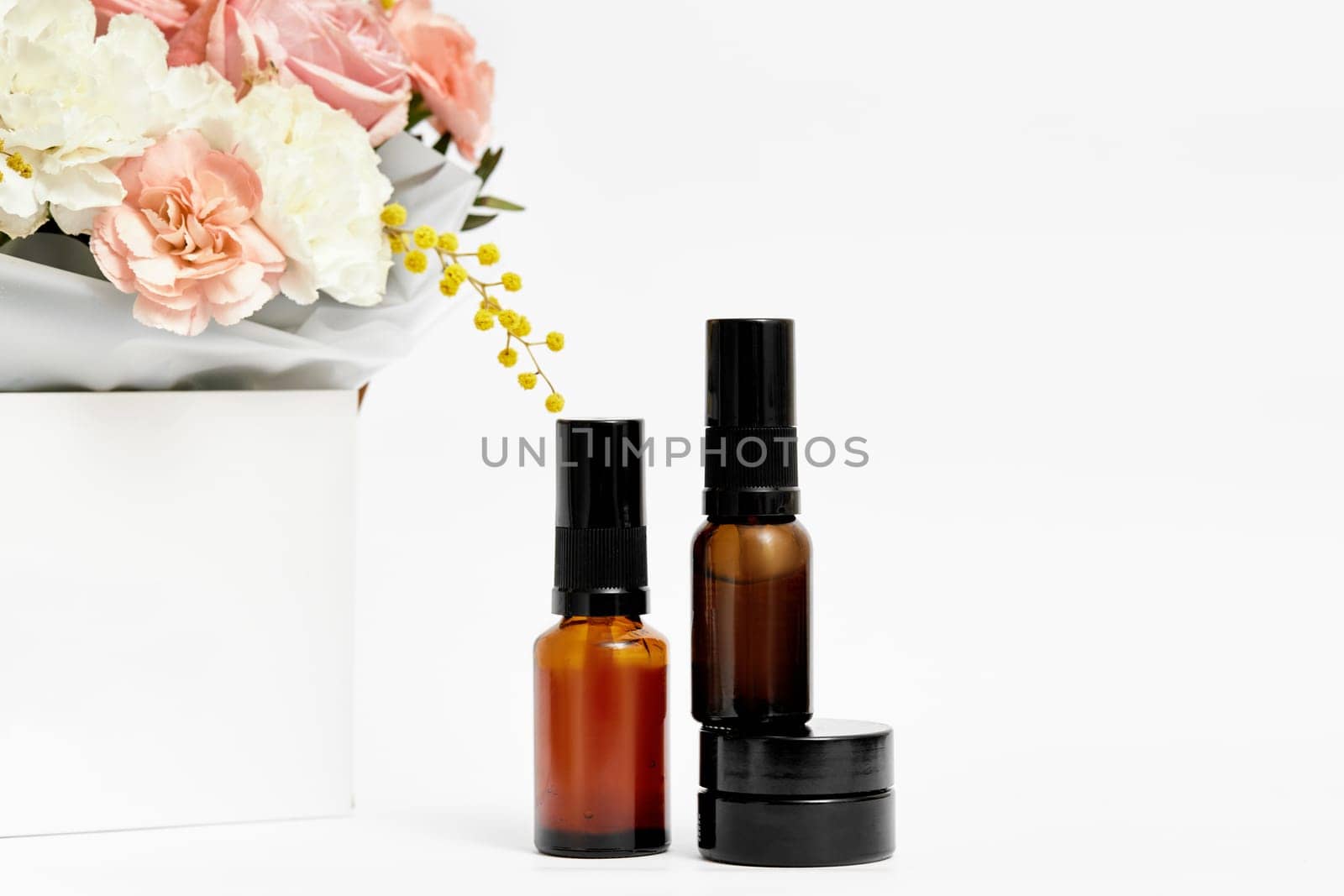 Small glass cosmetic bottle mockup with natural ingredient and flower. natural concept. copy space