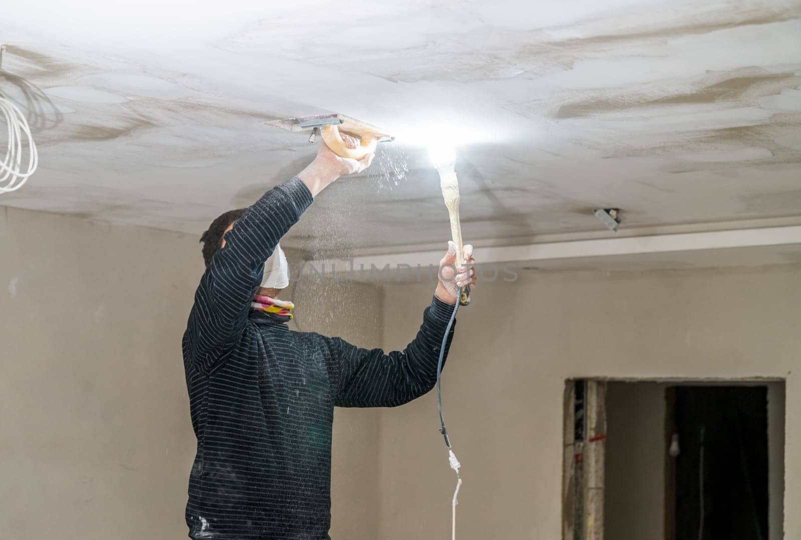 hand sanding of the plasterboard ceiling with a trowel.