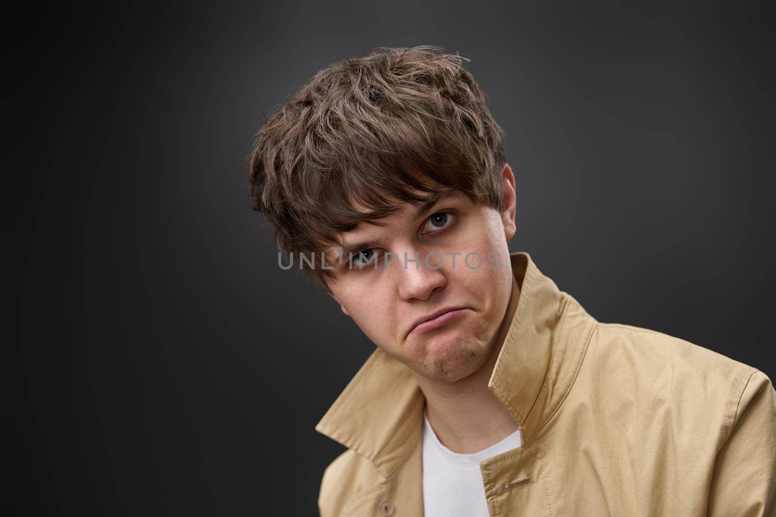 sad surprised man with hairstyle in coat on black background. fashion modern style look