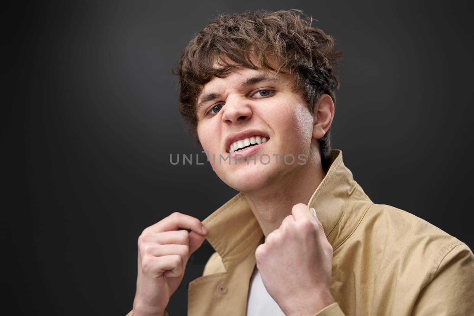 fashion caucasian man with hairstyle in coat on black background. modern style look