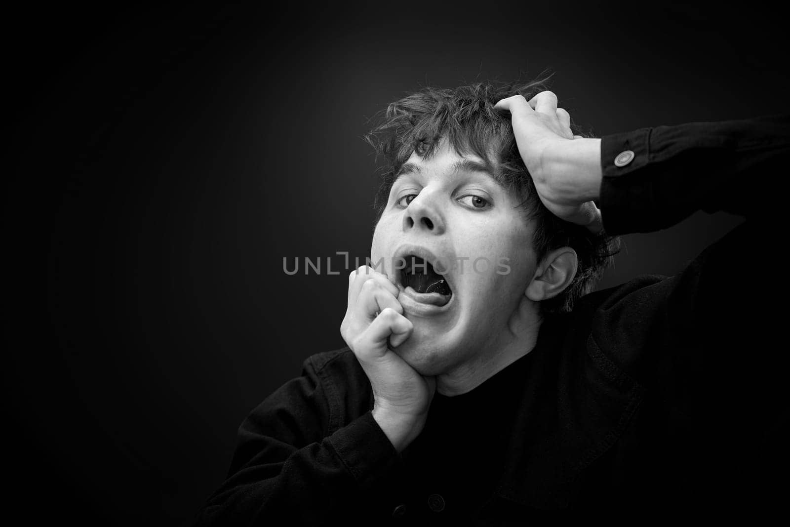 portrait of crazy young man yelling with a violent or desperate face and grimacing . black and white