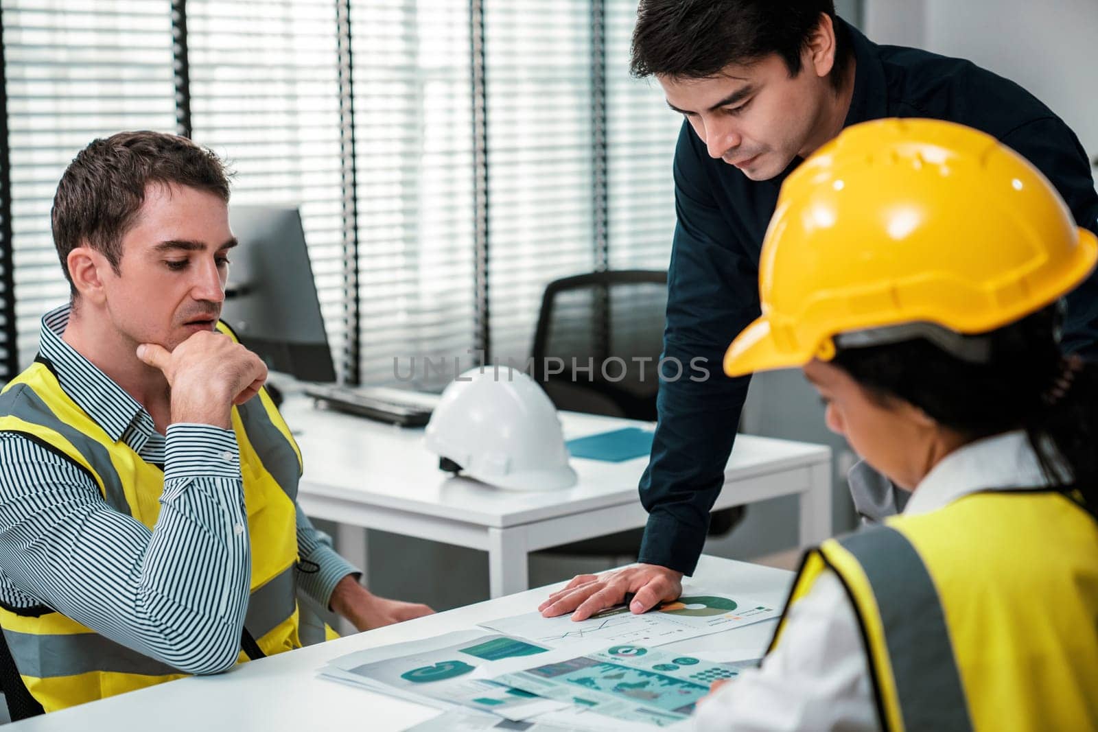 Engineers and competent employer discussing plans and blueprints together with tablet in the office. Concept of team contribution of ideas for engineering project.
