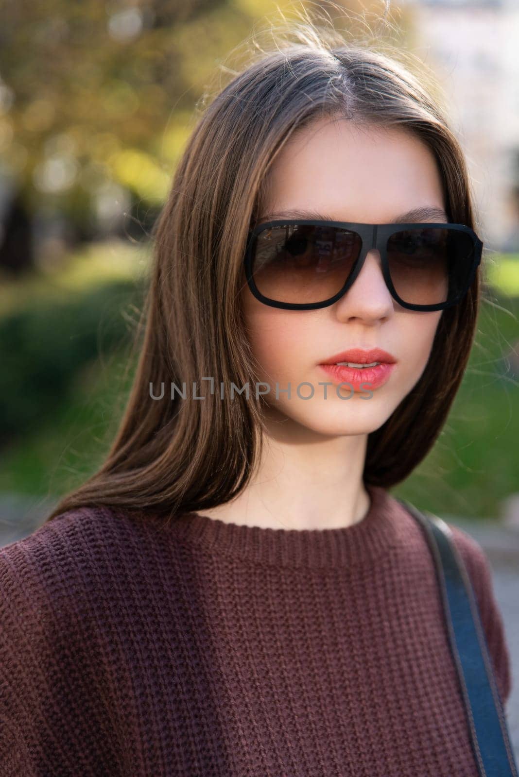 Close up shot of stylish young woman in sunglasses at the street. Beautiful female model.