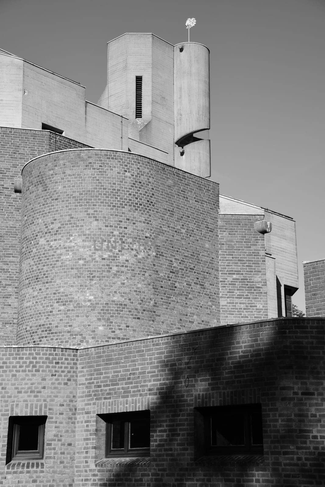Vertical grayscale shot of a church tower with a spiral staircase