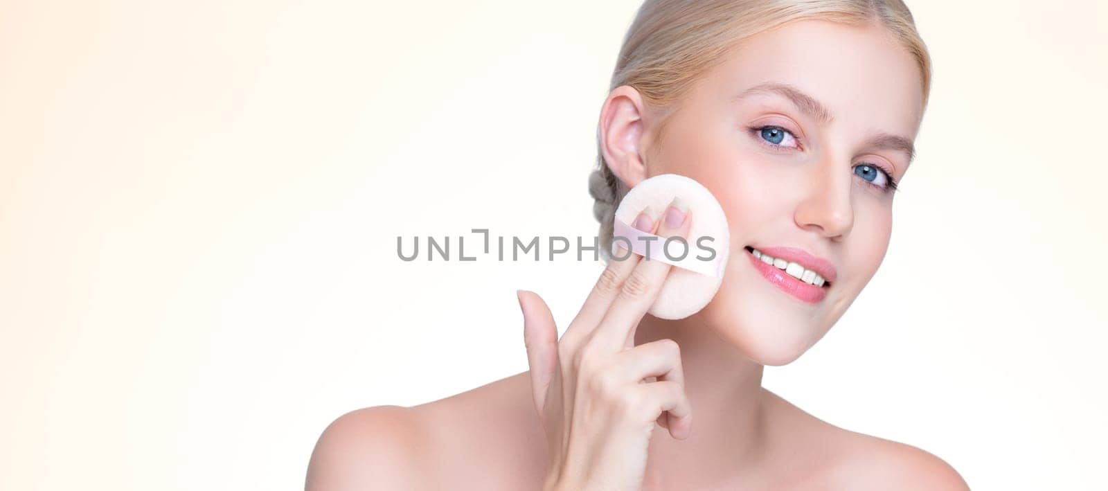 Personable beautiful natural soft makeup woman using powder puff for facial makeup concept. Cushion foundation applying on young girl face in isolated background.