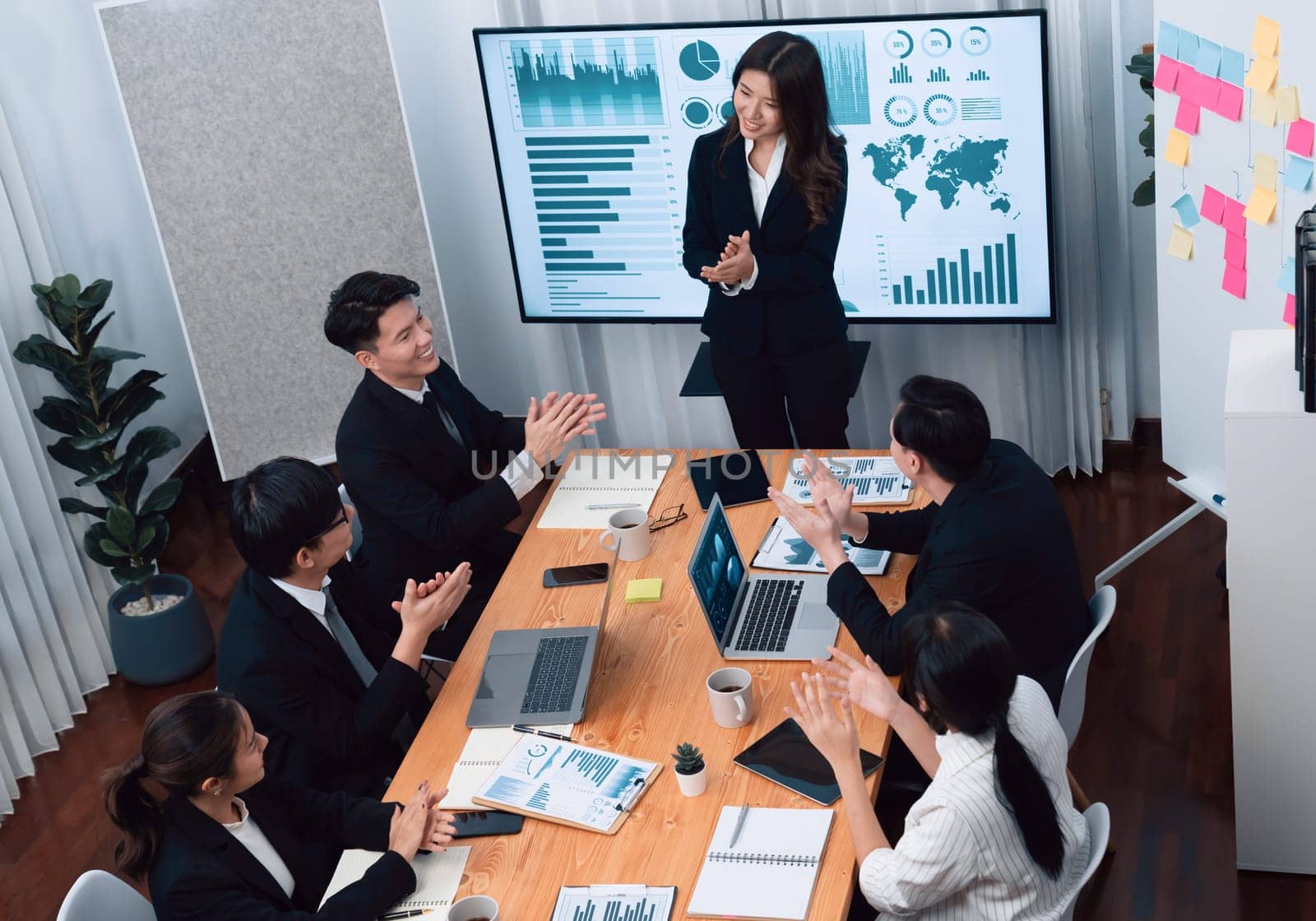 Top widen view of confidence of company presentation on financial analyzed by business intelligence in dashboard report with businesspeople in boardroom meeting to promote harmony in workplace concept