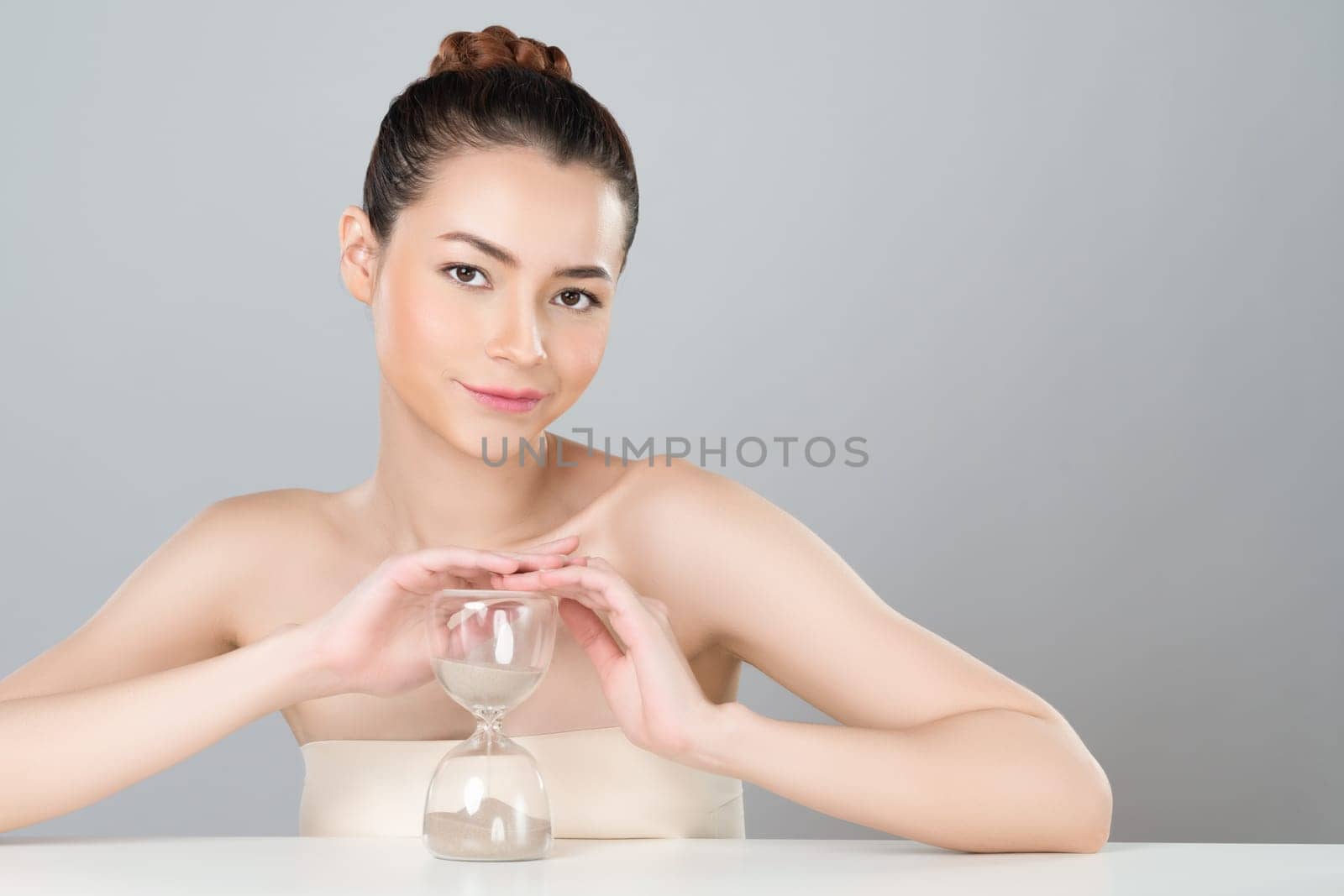 Glamorous beautiful woman with hourglass as anti-aging skincare concept by biancoblue
