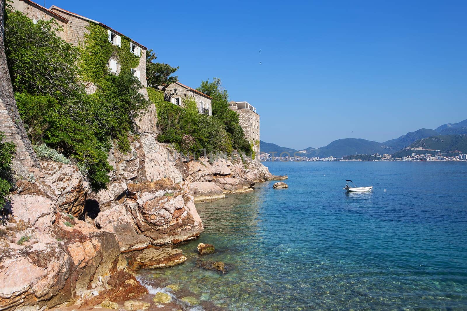 Famous architectural monument of the island-resort of St. Stephen St. Stephen in the Adriatic Sea, Montenegro. The concept of vacation at sea, boat in the sea. by sfinks