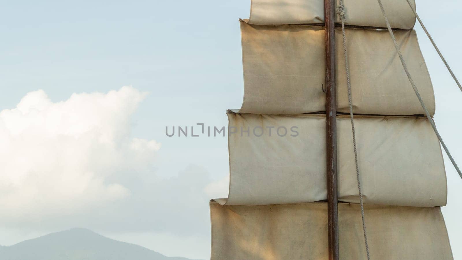 Cloth sail on a wooden mast in close-up against the sky by voktybre