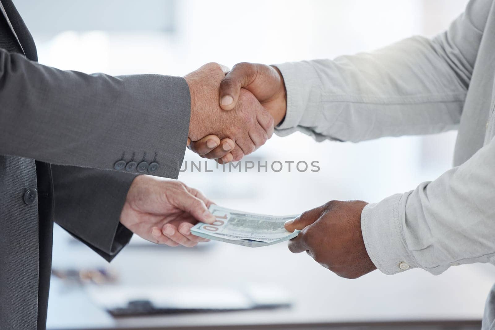 Handshake, money and crime with a business man taking a bribe in the office for a deal or agreement. Finance, payment and fraud with a male employee shaking hands in a partnership of corruption.