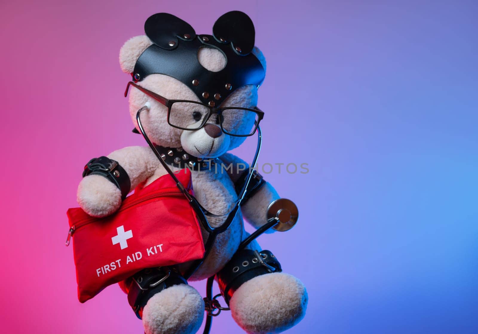 a toy teddy bear with leather straps and a mask for BDSM games with a first aid kit , safety and precautions in bdsm sex games
