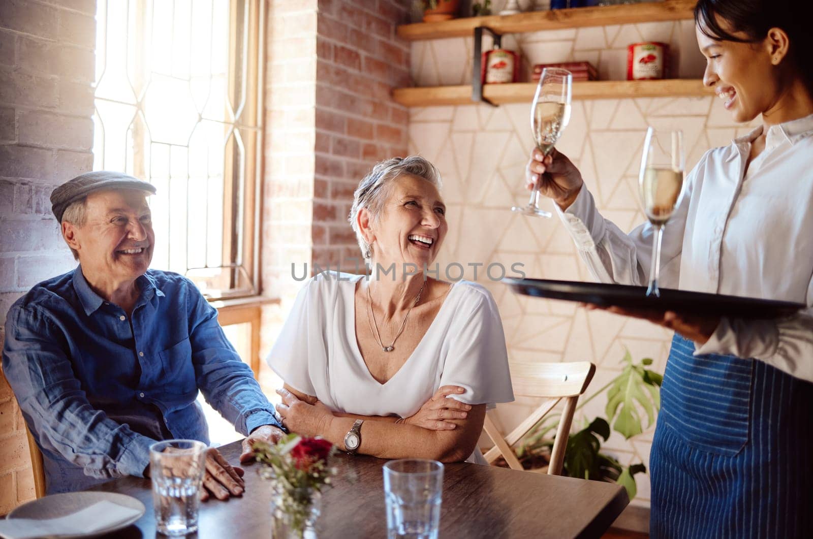 Senior couple, waiter and champagne in restaurant for wedding anniversary, celebration or birthday. Happy elderly man and woman smile with waitress and serve alcohol to celebrate retirement event.