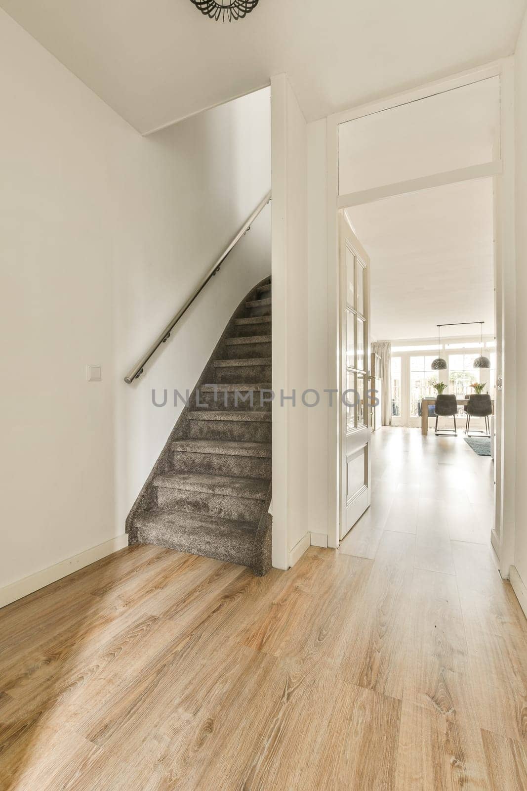 a staircase in a living room with a wooden floor by casamedia