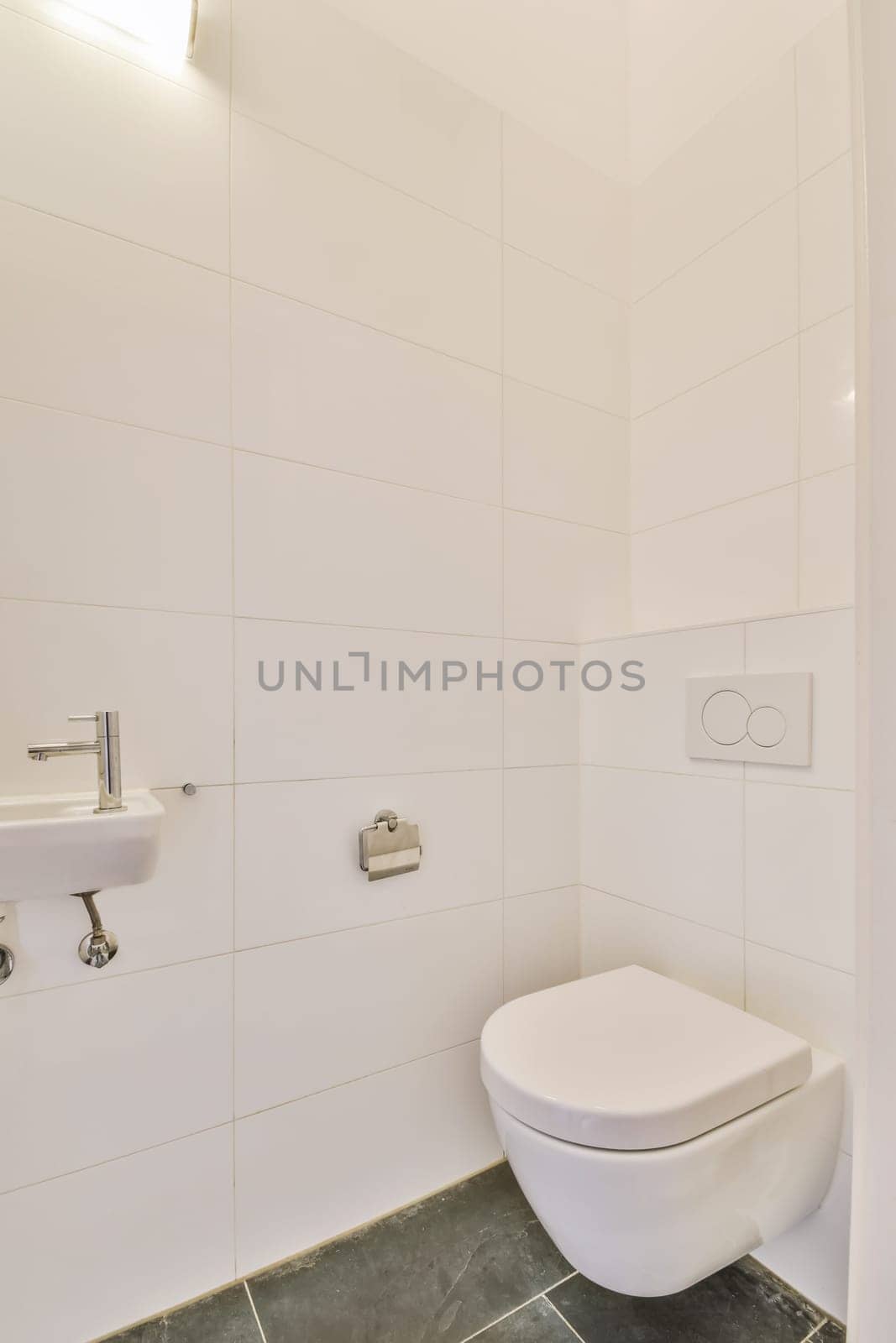 a white toilet in a bathroom with tile on the floor and wall behind it, there is a mirror above the toilet