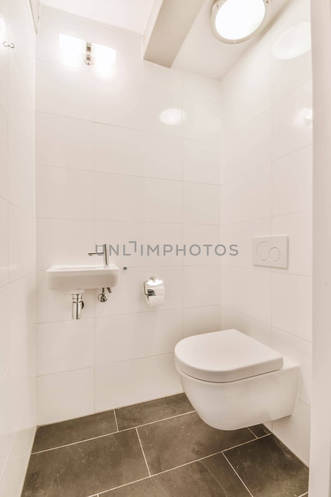 a white bathroom with a toilet and a sink by casamedia