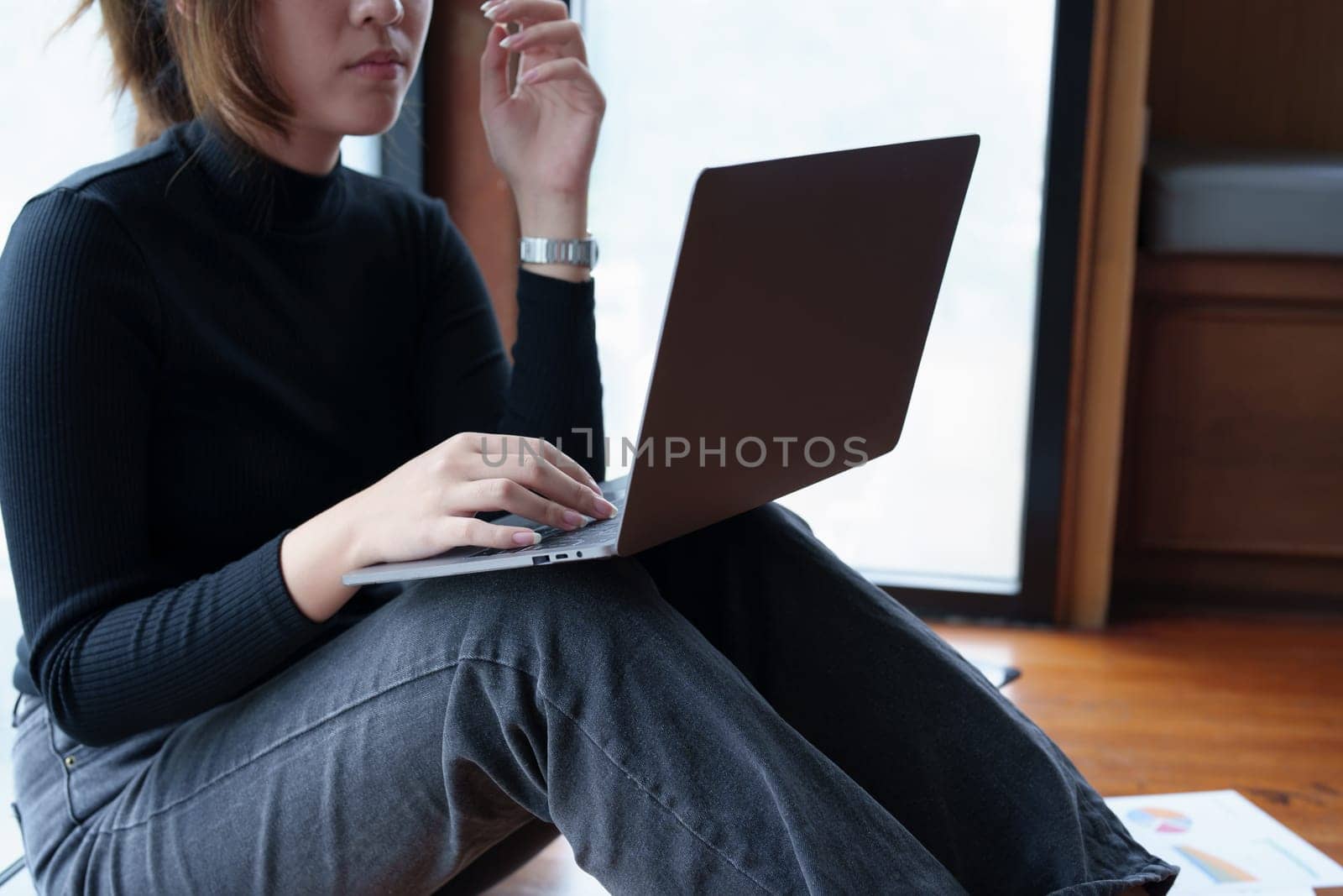 Portrait of an Asian woman using a computer to study online and drinking coffee while video conference by Manastrong