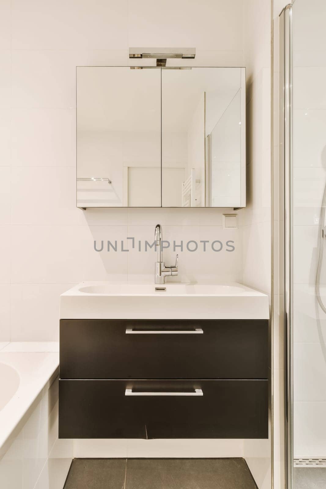a modern bathroom with black and white fixtures on the vanity, shower stall and toilet in the photo is taken