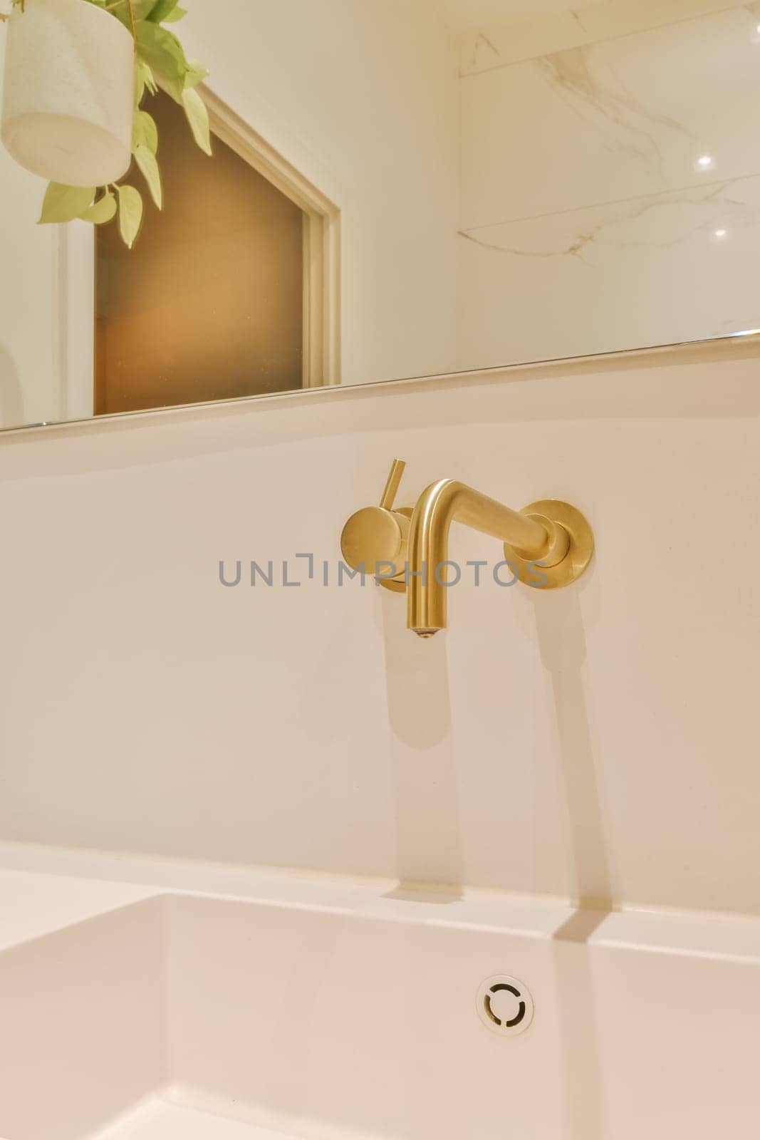 a white bathroom sink with a gold faucet by casamedia