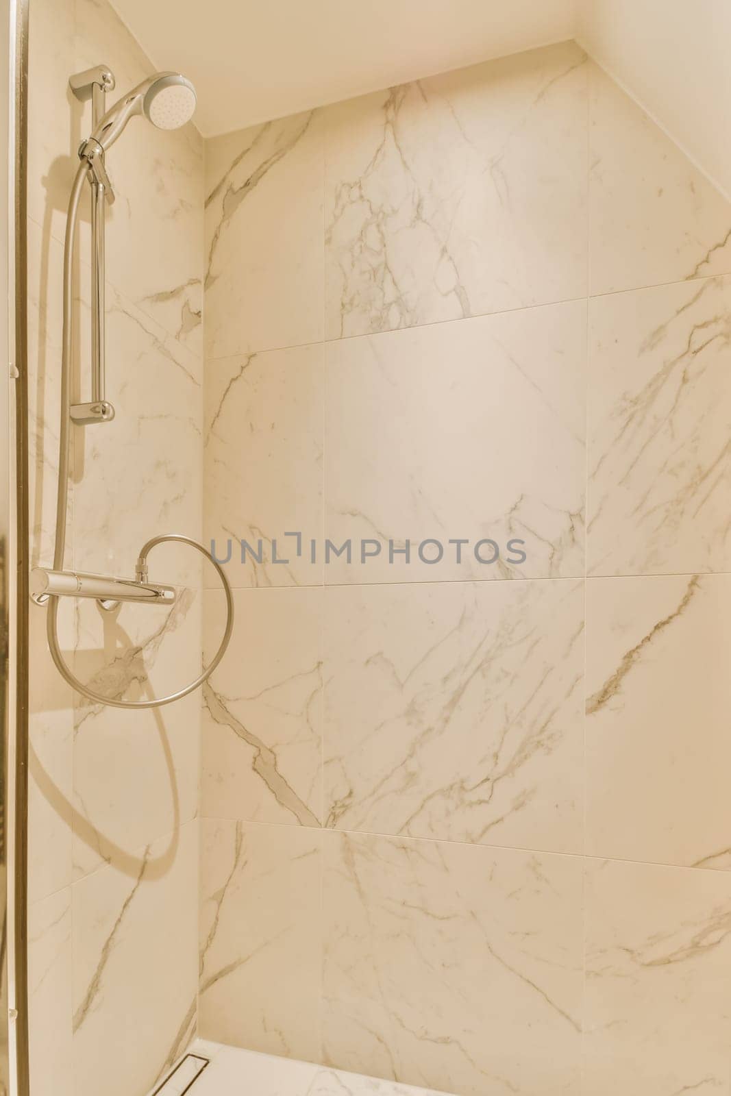 a shower with marble tiles in a bathroom by casamedia