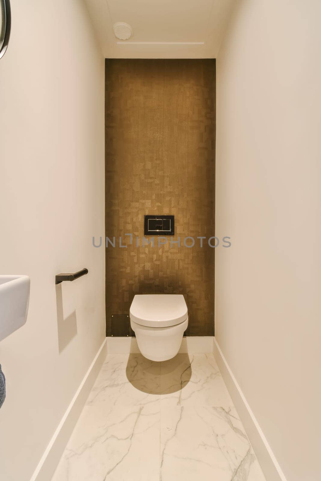 a small bathroom with a toilet and a brown wall by casamedia