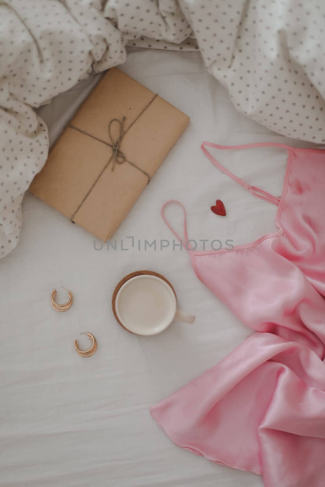 Light cozy bedroom, Coffee cup and gift or book on the bed. Good morning
